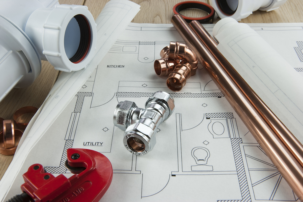 Plumbing supplies and tools over a home floorplan to understand your homes plumbing needs. Emergency plumbing service.