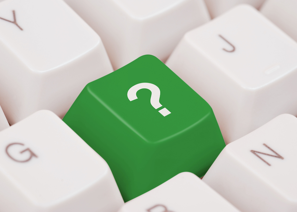Green question mark on keyboard representing FAQs about tankless water heater installation. 