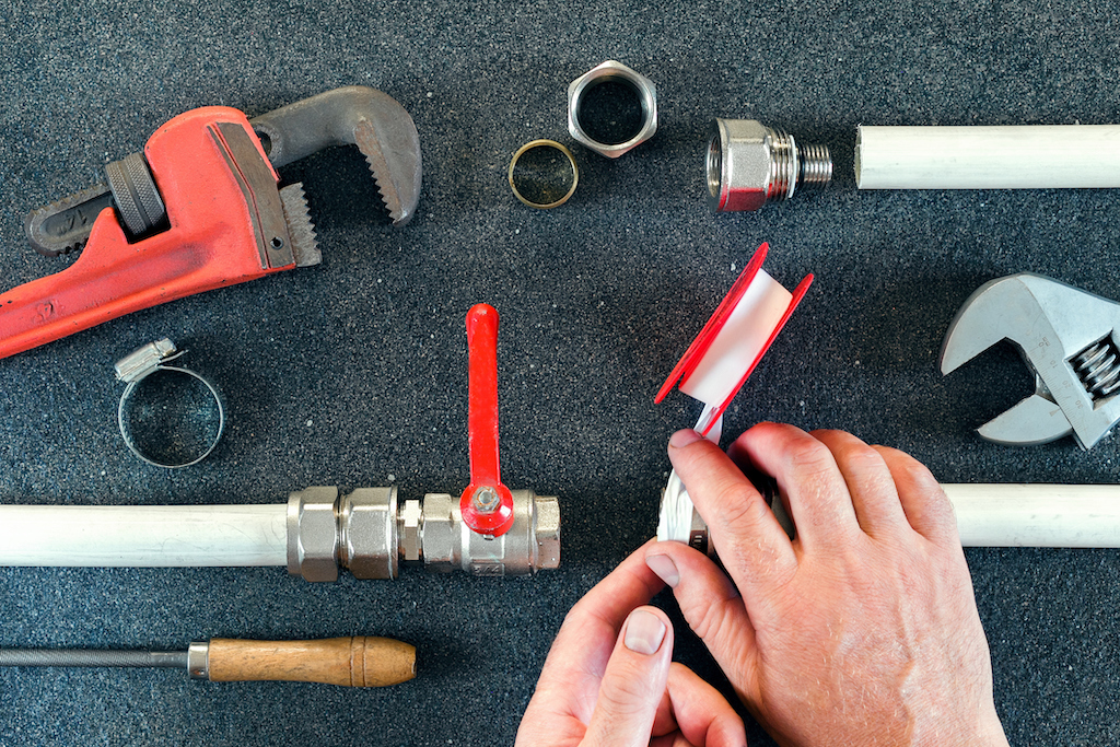 Plumber handling different plumbing tools. Whole home water filtration system.