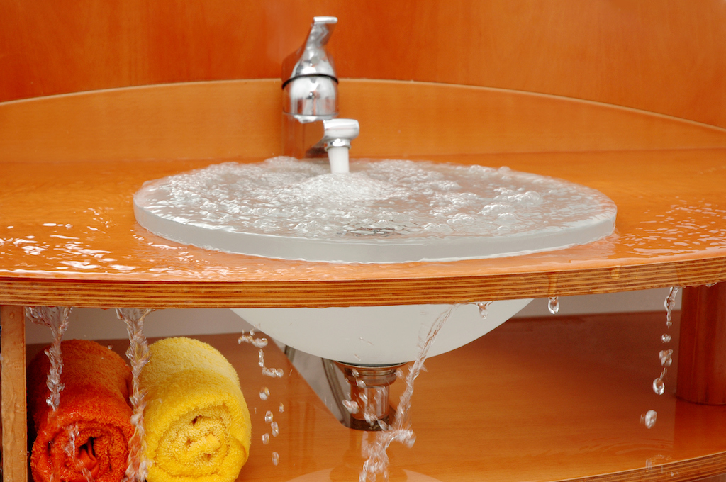 A bathroom sink overflows with water, in need of residential plumbing repair