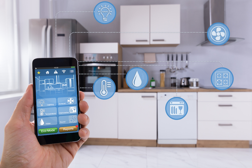 Person holding their smart phone to control kitchen. Kitchen Plumbing Installation.