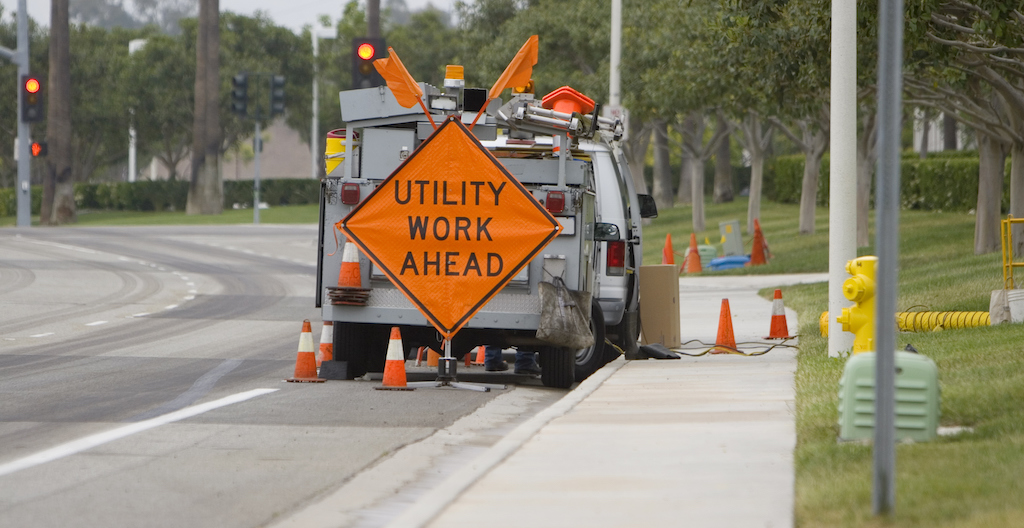 Work vehicle with 'Utlity Work Ahead' sign working on sewer line inspection.