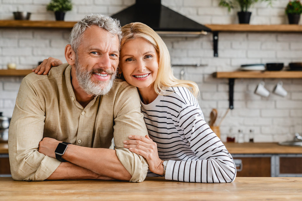 Happy couple smiling in kitchen. | Garbage Disposal Repair And Installation